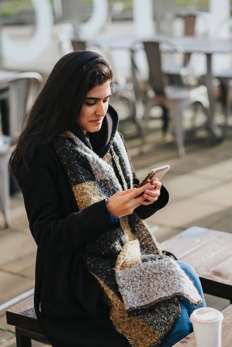 Iemand met telefoon op straat — sfeerbeeld